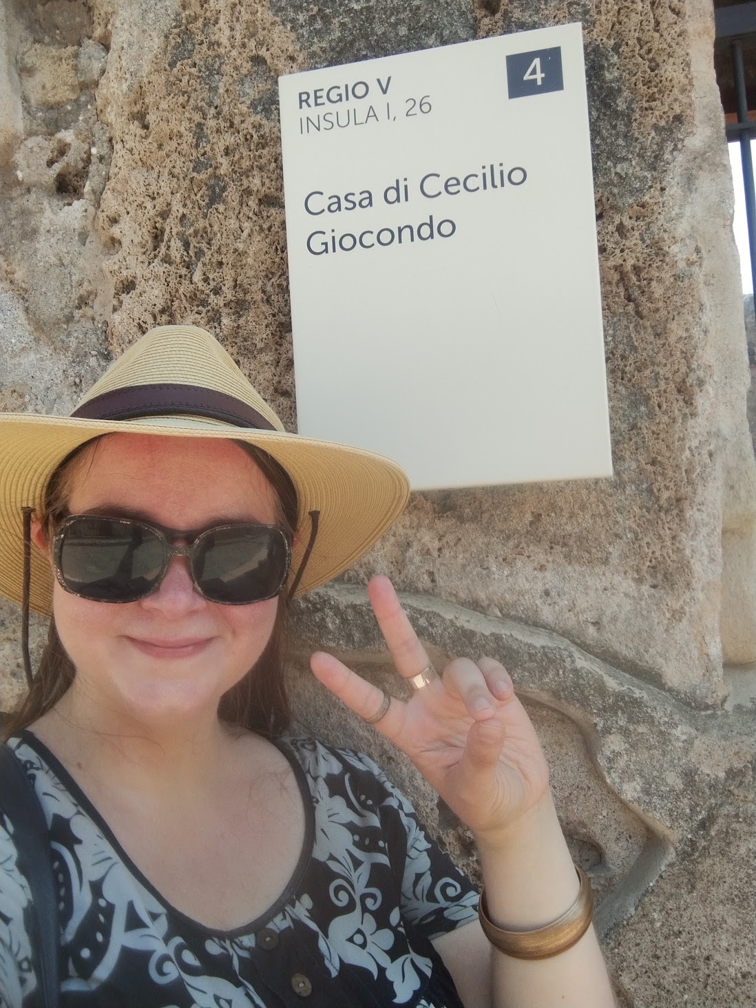 Astrid at the entrance sign of the Casa di Cecilio Giocondo, Pompeii